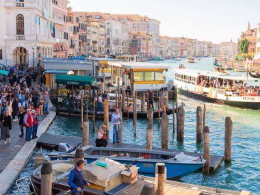 Venedik, İtalya. 28.10 dolar. 2022 yılı. İtalya, Venedik 'te Rialto Köprüsü ve gondolcularıyla Büyük Kanal manzarası. Rialto Köprüsü ve Venedik 'teki Grand Canal' da gondolla manzara. iyi havada bir sürü turist