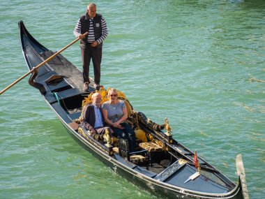 Venedik, İtalya. 28.10 dolar. 2022 yılı. İtalya, Venedik 'te Rialto Köprüsü ve gondolcularıyla Büyük Kanal manzarası. Venedik 'teki Grand Canal' da Rialto Köprüsü ve gondollu manzara