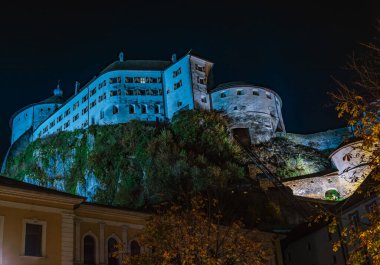 Kufstein, Avusturya 26.10.2022 eski Avusturya sınır kasabası. Gece sokakları, dağların tepesinde küçük beyaz bir kale