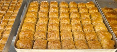 Altın katmanlar ve çıtır çıtır dokular sergilenen bir tepside sunulan enfes baklavalar..
