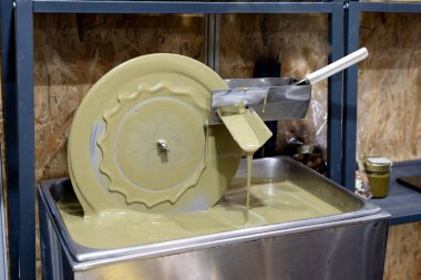 Fıstık ve fındık ezmesi işleme mekanizması. Metal daire fındık ezmesini karıştırıyor