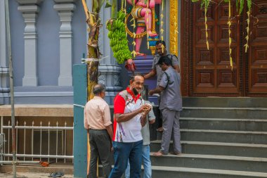 Colombo, Sri Lanka 03.02.2023, birçok renkli ruhani figürle eski bir Sri Lanka tapınağı. İnsanlar tapınak kapısından yiyecek alıyor.