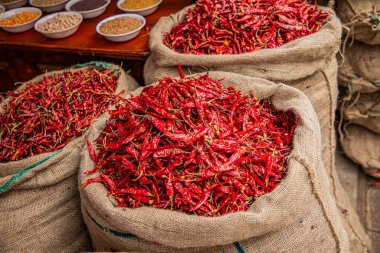 Sri Lanka 'daki yerel pazarda düzgünce düzenlenmiş çeşitli tropikal sebzeler. Kurutulmuş kırmızı biber poşetlerde.