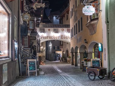 Kufstein, Avusturya 26.10.2022 eski Avusturya sınır kasabası. Gece sokakları, dağların tepesinde küçük beyaz bir kale