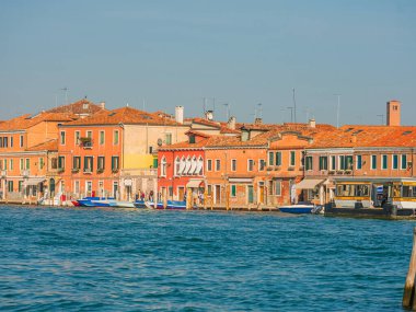 Murano, Venedik, İtalya Murano 29.10.2022 Kuzey lagün ve cam fabrikalarındaki ada. Gün batımında Venedik 'te Murano kanalları. Renkli eski evler ve köprüler kanal kıyılarını birbirine bağlıyor