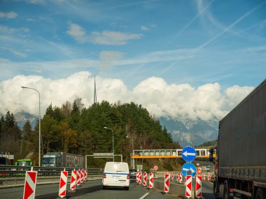Avusturya, Avrupa. 02.11.2022 Avusturya ve İtalya arasında otoban. Uçsuz bucaksız çitleri olan yollar, sonbaharda sararan ormanlarla kaplı alçak resimler arasında uzanır. Arabalar yol boyunca koşturuyor
