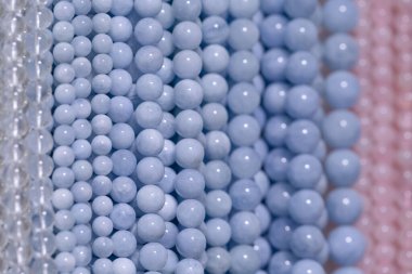 Mavi ve pembe tonlarda canlı boncukların detaylı yakın plan görüntüsü pürüzsüz dokularını ve sanatsal potansiyellerini vurguluyor..