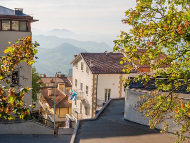 San Marino Cumhuriyeti. Dağdaki 31.10.2022 antik kale. Dar sokaklar turist, restoran ve hediyelik eşya dükkanlarıyla dolu. Aşağıda gün batımında güzel bir dağ manzarası var.