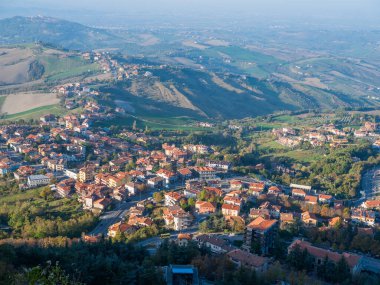 San Marino Cumhuriyeti. Dağdaki 31.10.2022 antik kale. Dar sokaklar turist, restoran ve hediyelik eşya dükkanlarıyla dolu. Aşağıda gün batımında güzel bir dağ manzarası var.