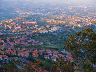 San Marino Cumhuriyeti. Dağdaki 31.10.2022 antik kale. Dar sokaklar turist, restoran ve hediyelik eşya dükkanlarıyla dolu. Aşağıda gün batımında güzel bir dağ manzarası var.
