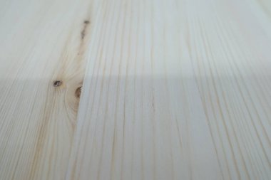 Hafif ahşap yüzeyin detaylı yakın çekimi, özgün tahıl desenlerini ve dokularını vurgulamak, arka plan ve tasarım projeleri için ideal.