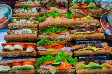 Taze sebzeler, etler ve peynirlerle dolu gurme sandviçler. Renkli bir gösteri için güzelce düzenlenmiş..