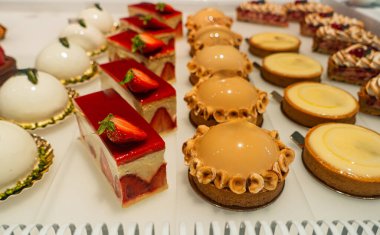 Bir pastanede çeşitli dokular ve tatlar sunan, tatlı bir hoşgörüyü davet eden canlı bir gurme tatlısı seçimi..