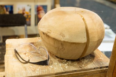 Ahşap kase, ahşap talaşı ve güvenlik gözlükleri ile çevrili, ahşap bir tezgahta hazırlanıyor..