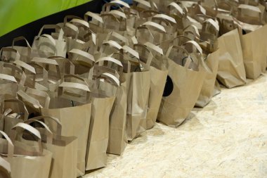 Çevre dostu kese kağıtları, sürdürülebilir alışveriş seçenekleri ve çevre bilincinin gösterildiği ahşap bir yüzeyde düzenli bir sıra halinde düzenlenir..