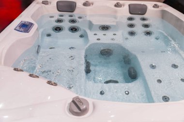 Temiz suyla dolu çağdaş bir jakuzi, gevşemek ve keyif almak için tasarlanmış jetler ve kabarcıklar..