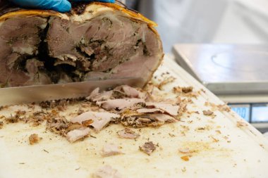 Büyük bir somun taze çiftlik jambonu ve sosis satışa hazır ve parça parça kesilmiş.