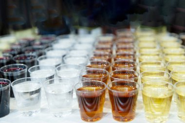 Farklı içeceklerle dolu canlı bir içecek bardağı görüntüsü, çeşitli renk ve dokuları düzenli bir şekilde sergiliyor..