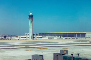 Doha, Katar - 02 Şubat 2023: Modern havaalanı kontrol kulesi açık mavi gökyüzüne karşı dimdik ayakta duruyor.