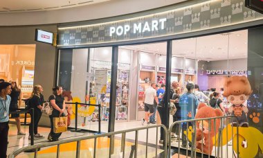 Berlin, Almanya. 27 Ağustos 2025. Market içi ziyaretçileri bakınıyor. Raflarda koleksiyon figürleri ve ürünler sergilenirken, cam anonslarda satılan Labubu serileri çeşitli tabelalar yer alıyor.