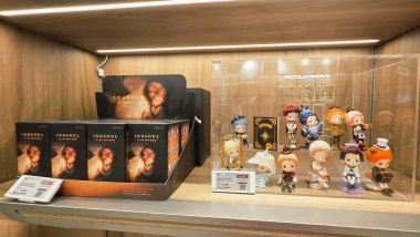 Berlin, Almanya. 27 Ağustos 2025. Market içi ziyaretçileri bakınıyor. Raflarda koleksiyon figürleri ve ürünler sergilenirken, cam anonslarda satılan Labubu serileri çeşitli tabelalar yer alıyor.