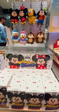 Berlin, Almanya. 27 Ağustos 2025. Market içi ziyaretçileri bakınıyor. Raflarda koleksiyon figürleri ve ürünler sergilenirken, cam anonslarda satılan Labubu serileri çeşitli tabelalar yer alıyor.