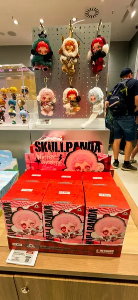 Berlin, Almanya. 27 Ağustos 2025. Market içi ziyaretçileri bakınıyor. Raflarda koleksiyon figürleri ve ürünler sergilenirken, cam anonslarda satılan Labubu serileri çeşitli tabelalar yer alıyor.