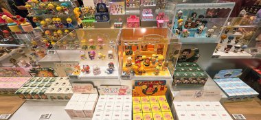 Berlin, Almanya. 27 Ağustos 2025. Market içi ziyaretçileri bakınıyor. Raflarda koleksiyon figürleri ve ürünler sergilenirken, cam anonslarda satılan Labubu serileri çeşitli tabelalar yer alıyor.