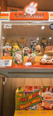 Berlin, Almanya. 27 Ağustos 2025. Market içi ziyaretçileri bakınıyor. Raflarda koleksiyon figürleri ve ürünler sergilenirken, cam anonslarda satılan Labubu serileri çeşitli tabelalar yer alıyor.