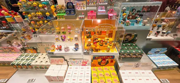 Berlin, Almanya. 27 Ağustos 2025. Market içi ziyaretçileri bakınıyor. Raflarda koleksiyon figürleri ve ürünler sergilenirken, cam anonslarda satılan Labubu serileri çeşitli tabelalar yer alıyor.