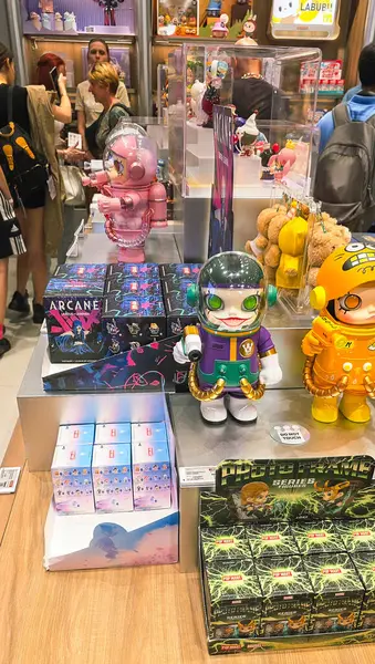Berlin, Almanya. 27 Ağustos 2025. Market içi ziyaretçileri bakınıyor. Raflarda koleksiyon figürleri ve ürünler sergilenirken, cam anonslarda satılan Labubu serileri çeşitli tabelalar yer alıyor.