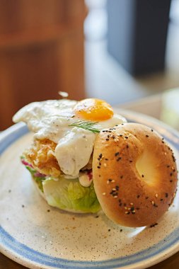 Kızarmış tavuk ve kızarmış yumurta ile bagel sandviçi.
