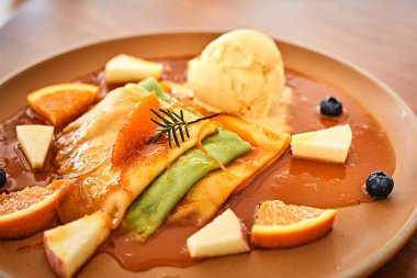 Vanilyalı krep, portakal sosu ve taze portakal.