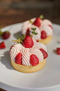 Çilekli turtaları krema sosuyla kapat.