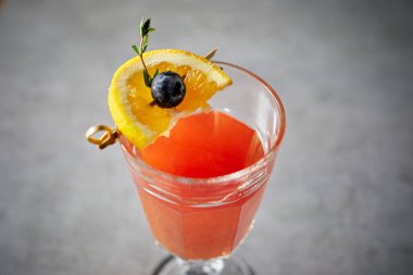 Arkaplanda portakal suyu olan yaratıcı bir kokteyl..