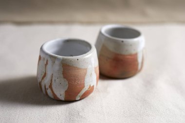 Handmade empty craft ceramic on  textile background.