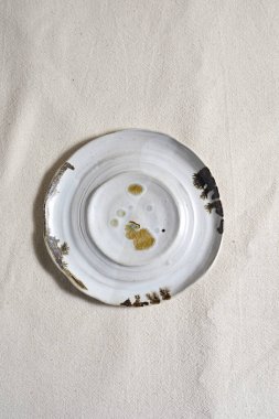 Handmade empty craft ceramic on  textile background.