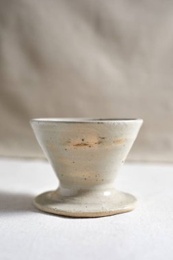 Handmade coffee dripper ceramic on  textile background