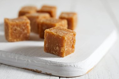 Beyaz arkaplanda kahverengi kamış şekerini kapat, seçici odak noktası