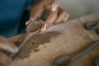 Küçük bir kil Spoo 'yu şekillendiren ellere yaklaş