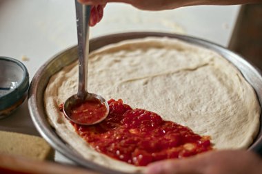 Pizza tavasına domates sosu serpiştirmek, seçici odaklanma