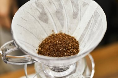 Alternatif kahve demleme metodu, damlatıcı ve kağıt filtresinin üzerine dökülüyor.