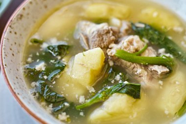 Restoran masasında domuz pirzolası ve patates çorbası.