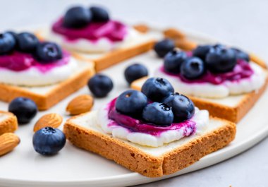 Böğürtlen krem peynirli tost, taze yaban mersini, kızarmış badem, bulanık popo.