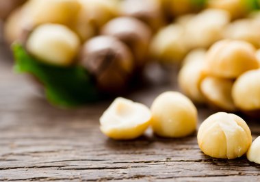 Macadamia fındıkları ahşap masanın üzerinde, bulanık arka gruplama