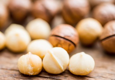 Macadamia fındıkları ahşap masanın üzerinde, bulanık arka gruplama