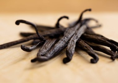 Kahverengi arka planda vanilya fasulyesini kapat, bulanıklaştır