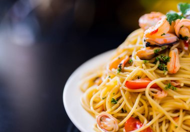 Siyah masadaki deniz mahsullü spagettiyi kapat.