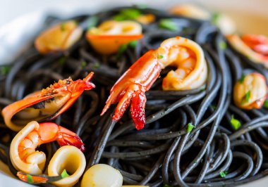 Siyah masadaki deniz mahsullü siyah spagettiyi kapat.