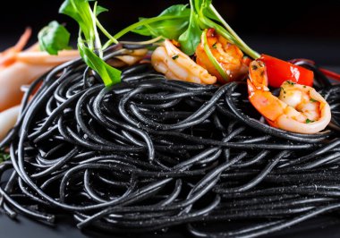 Siyah masadaki deniz mahsullü siyah spagettiyi kapat.